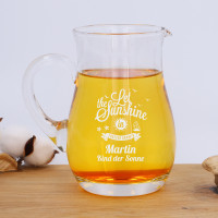 Glaskrug mit Gravur auf Tisch