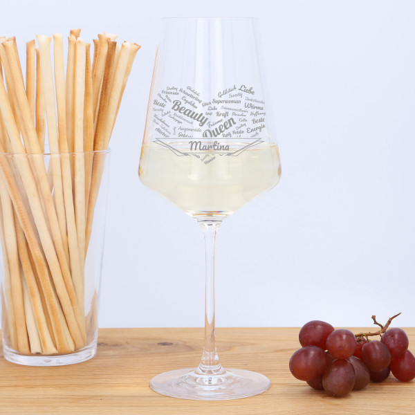 Weißweinglas mit Gravur (auf Tisch mit Trauben und Knappersticks stehend)