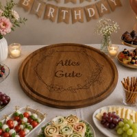 Großes rundes Brotzeitbrett aus Holz, Ø 42 cm, mit Gravur liegt auf einem Buffettisch